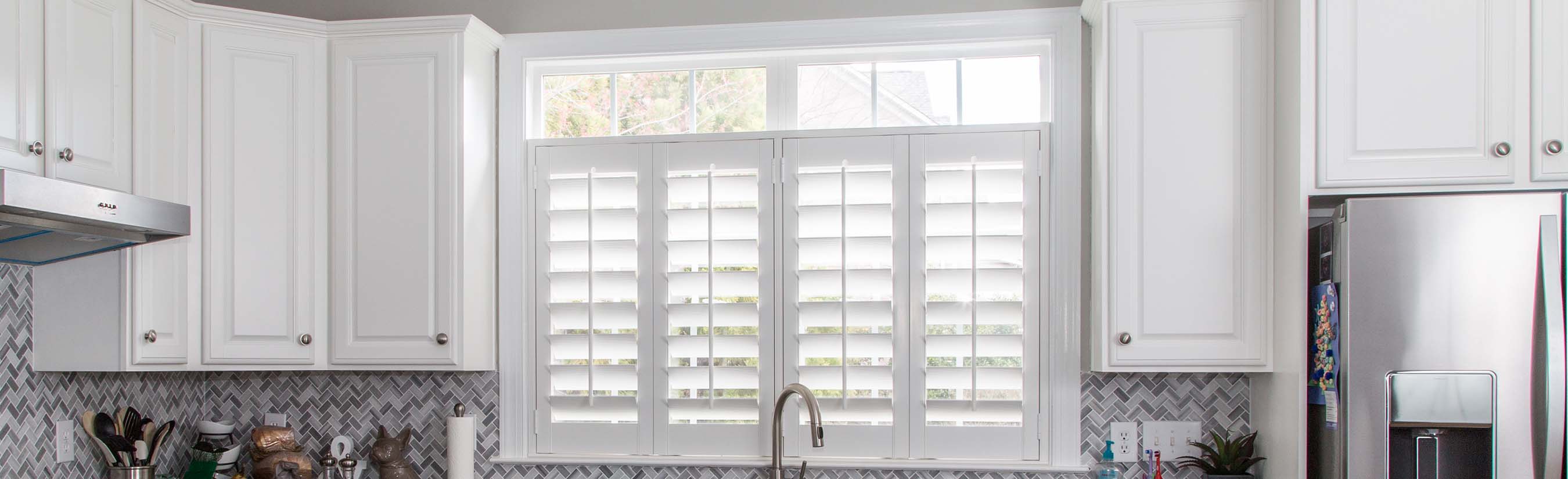 White cafe shutters above a kitchen sink.