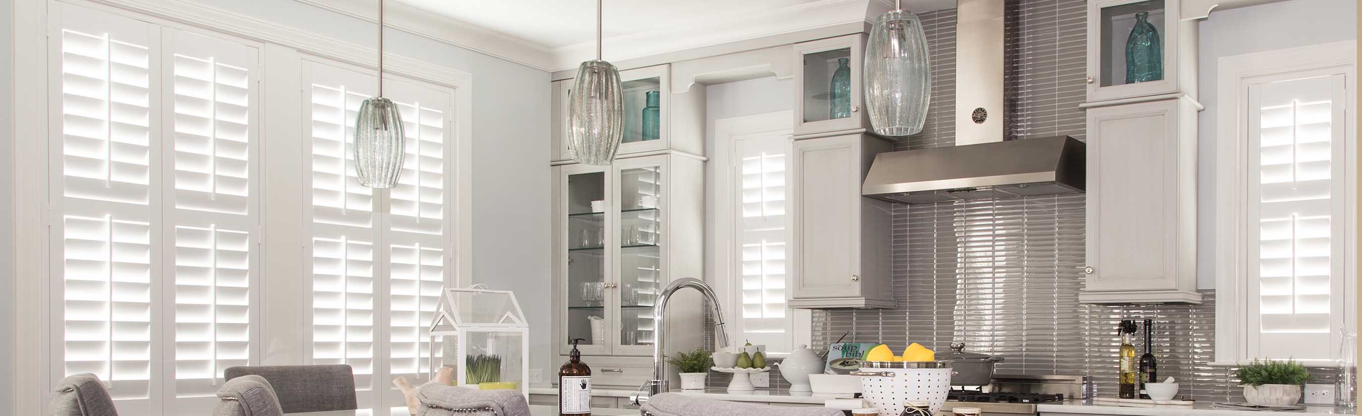 White plantation shutters in a white modern kitchen.