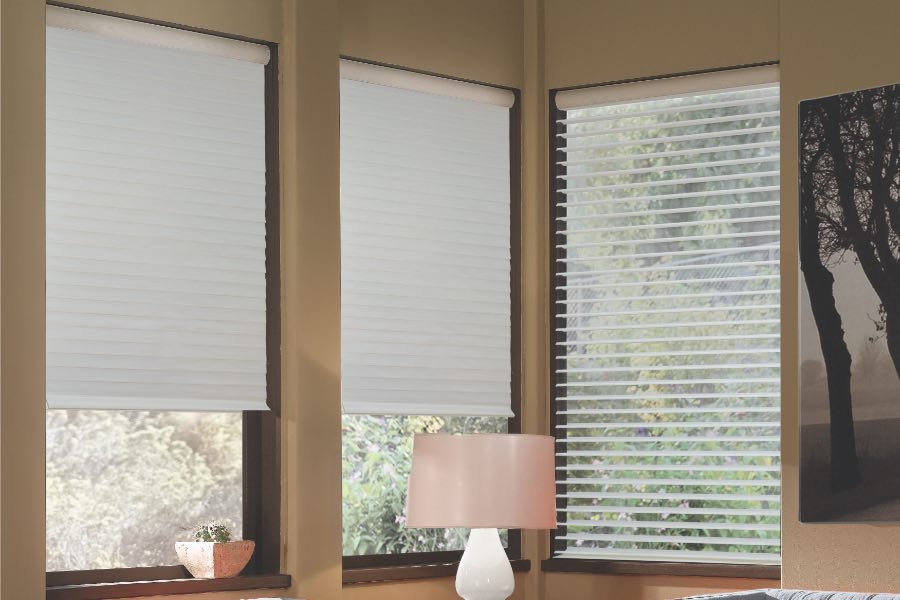 Opaque motorized window shades in Cincinnati keep hot UV rays out of your home. Gray motorized sheer shades on corner windows next to gray furniture