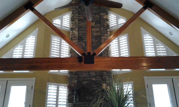 Slanted windows on tan wall with stone divider.