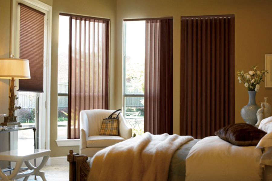 Choose durable and high-quality fabric or vinyl vertical blinds in Cincinnati. Maroon fabric vertical blinds inside a bedroom
