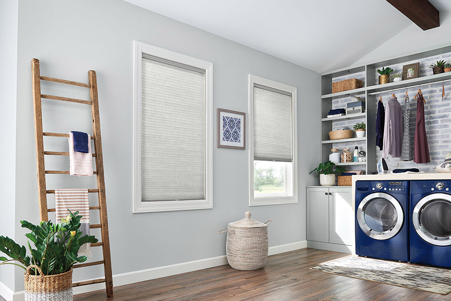 If you want privacy in your laundry room, choose window treatments that completely block the view when closed. Gray cellular shades on windows in a gray laundry room