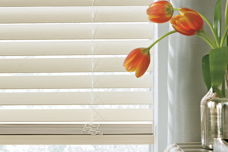 Capture the beauty of your home with Polywood faux-wood blinds. Up close shot of beige Polywood blinds.