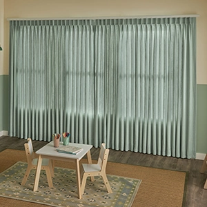 Sage green draperies closed on a several large windows in a playroom